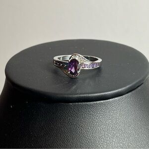 Silver tone ring with purple stone and accents. Size 8